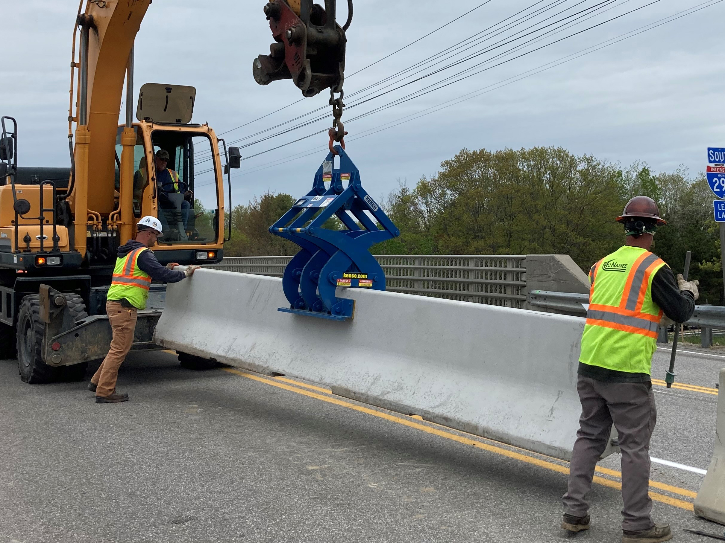 Machines placing barricades near bridge